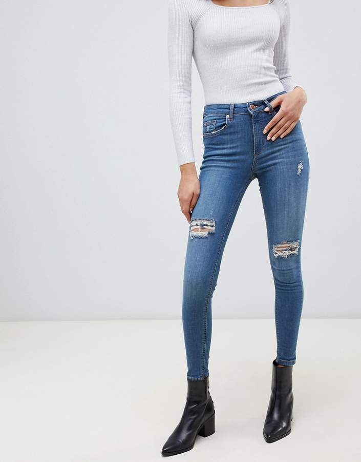 skinny jeans with distressed rips in mid wash