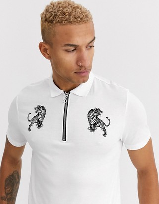 ASOS DESIGN polo with tiger print and zip neck collar