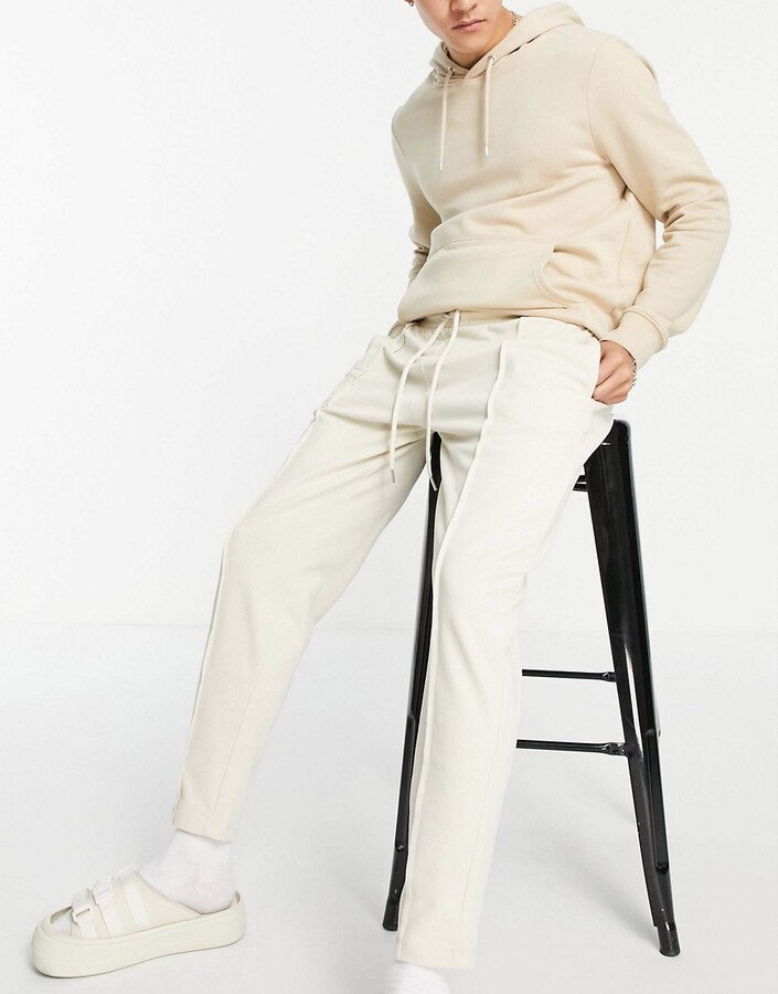 ASOS DESIGN smart pique tapered joggers with fixed hem \u0026 pin tucks in beige  - ShopStyle Trousers
