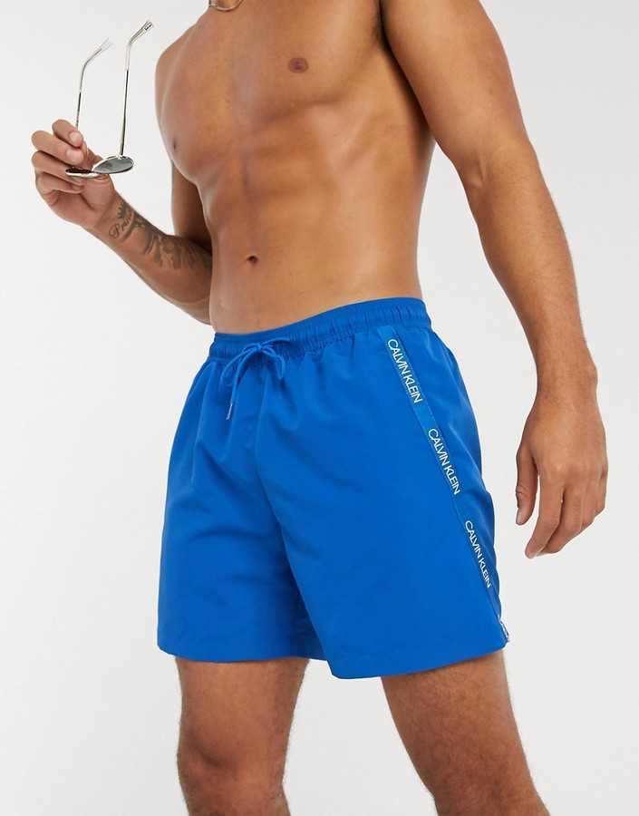 Calvin Klein medium length swim trunks in blue - ShopStyle