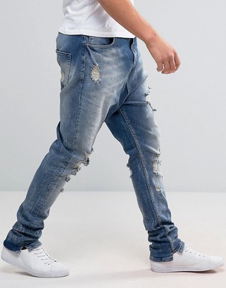 ASOS Drop Crotch Stacked Jeans With Rips And Bleaching In Mid Blue
