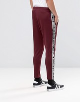Thumbnail for your product : adidas Taping Joggers In Red AY8266