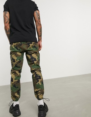 ASOS DESIGN tapered cargo pants with toggles in camo print