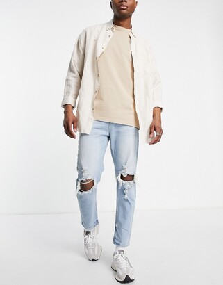 ASOS DESIGN tapered carrot jeans in light wash blue with knee rips -  ShopStyle