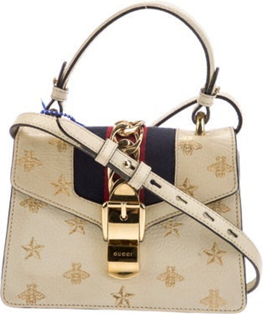 Gucci Shoulder Bag Metallic & Neutrals Leather Sylvie Web Accent & Bee Accent Gold-Tone Hardware Flat Handle & Single Adjustable Shoulder Strap Grosgrain & Chain-Link Accents Nylon Lining & Single Interior Pocket Turn-Lock & Flap Closures at Front Unfortunately due to restrictions this item may not be eligible for shipping in all areas.
