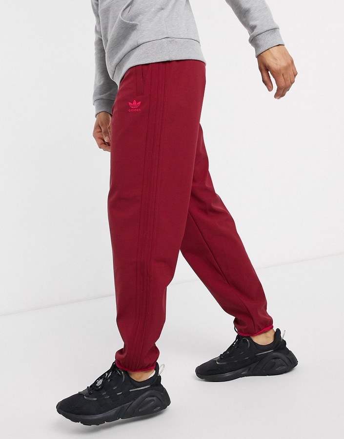 red adidas pants with black stripes