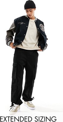 ASOS DESIGN oversized varsity jacket with faux leather sleeves in navy