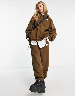 nike all over logo print joggers in camel