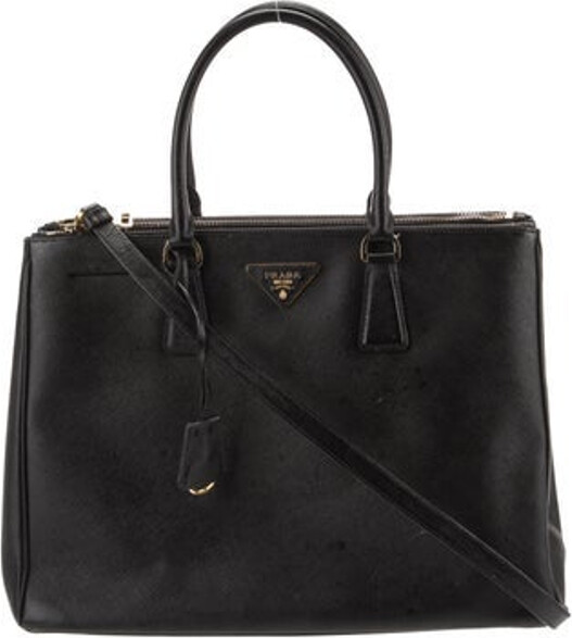 Prada Shoulder Bag Nero Saffiano Lux Leather Gold-Tone Hardware Rolled Handles & Single Adjustable Shoulder Strap Leather Trim Embellishment & Dual Exterior Pockets Logo Jacquard Lining & Four Interior Pockets Open Top Protective Feet at Base Includes Dust Bag, Authenticity Card & Clochette