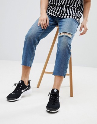 Mennace Tapered Jeans In Midwash Blue With Knee Rip