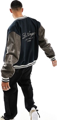 ASOS DESIGN oversized varsity jacket with faux leather sleeves in navy