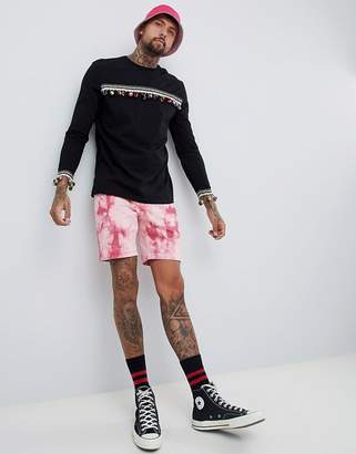 ASOS DESIGN festival relaxed longline long sleeve t-shirt with pom-pom chest and cuff