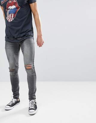 ASOS DESIGN super skinny jeans in washed black with side stripe and knee rips