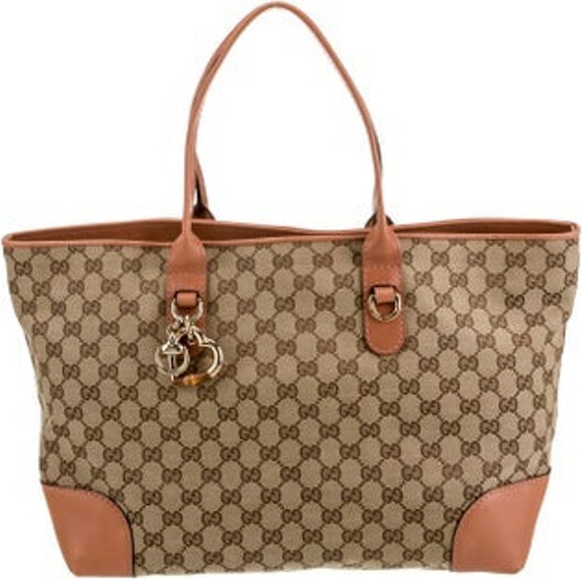 Gucci Tote Neutrals Canvas GG Canvas Gold-Tone Hardware Leather Trim Flat Handles Leather Trim Embellishment Canvas Lining & Three Interior Pockets Clasp Closure at Top Protective Feet at Base