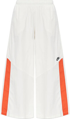 nike all over logo print joggers in camel