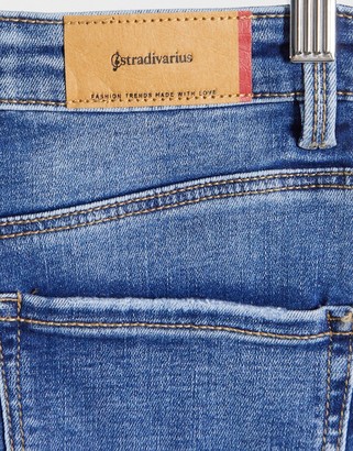 Stradivarius super high waist skinny jeans in with rip in medium blue