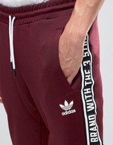 Thumbnail for your product : adidas Taping Joggers In Red AY8266