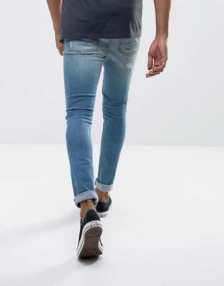 ASOS DESIGN Super Skinny Jeans In Vintage Mid Wash Blue With Rip And Repair Detail