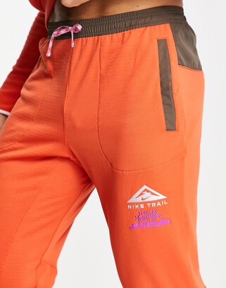 orange nike track pants