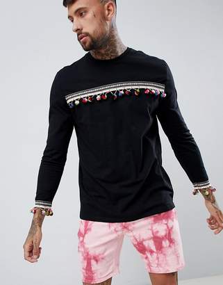 ASOS DESIGN festival relaxed longline long sleeve t-shirt with pom-pom chest and cuff
