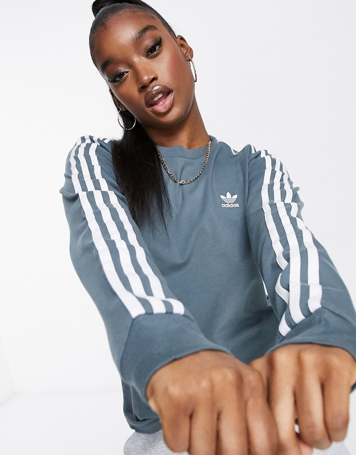 adidas adicolor three stripe long sleeve t-shirt in blue oxide - ShopStyle  Activewear Tops