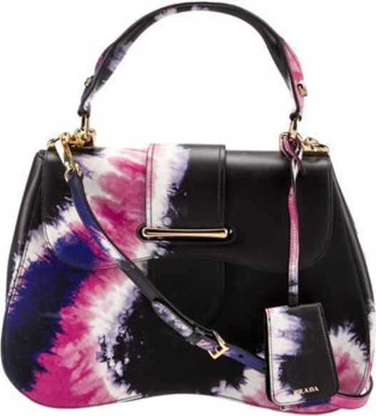 Prada Top Handle Bag Nero City Calf Leather Tie-Dye Print Gold-Tone Hardware Rolled Handle & Single Adjustable Shoulder Strap Leather Lining & Dual Interior Pockets Flap & Pull-Through Closures at Front Includes Luggage Tag Unfortunately, due to restrictions, this item may not be eligible for shipping in all areas.