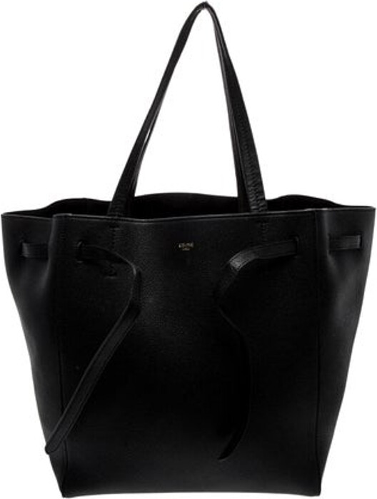 Celine Tote From the Fall 2022 Collection by Hedi Slimane Black Leather Gold-Tone Hardware Dual Shoulder Straps Suede Lining & Three Interior Pockets Drawstring Closure at Front Includes Dust Bag Unfortunately, due to restrictions, this item may not be eligible for shipping in all areas.
