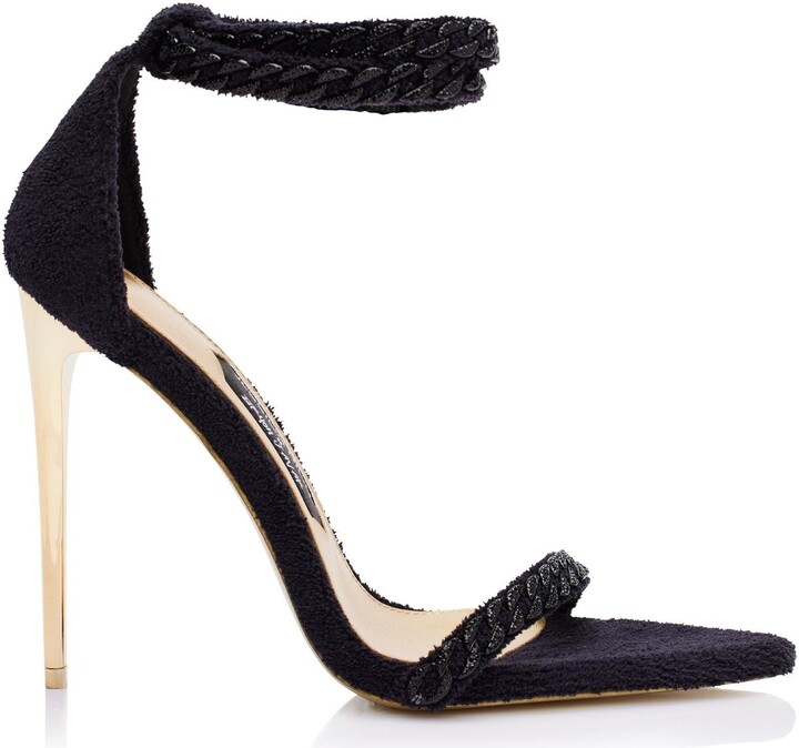 JESSICA RICH This iconic line of must-have heels blends elegance with modern flair, offering the perfect statement piece for any wardrobe. One of the most unique designs in this collection is The Lisa Sandal. This shoe is equal parts cozy and classy with its terry cloth fabric and monochromatic diamanté chain embellishments.