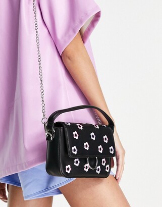Skinnydip crossbody bag in black with pastel daisy embellishment