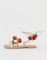 Thumbnail for your product : ASOS Design DESIGN Fun Fair pom pom leather tie leg flat sandals-Beige