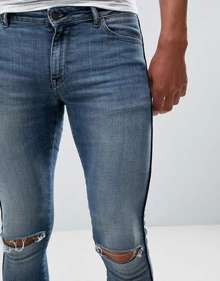 ASOS Design Extreme Super Skinny Jeans In Mid Wash With Rips And Side Stripe