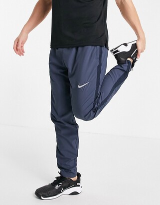 Nike Running Dri-FIT woven joggers in dark blue - ShopStyle Trousers