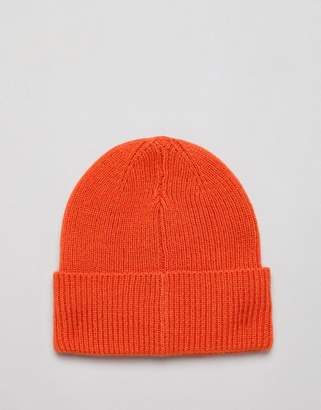 ASOS DESIGN oversized beanie in orange with rubber badge detail
