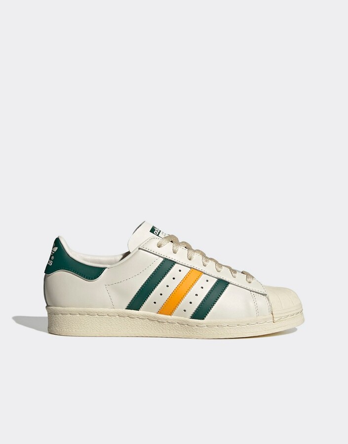 adidas Superstar trainers in white and green with yellow stripes - ShopStyle