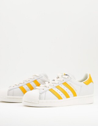 adidas Superstar trainers in white and yellow - ShopStyle