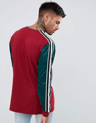 ASOS Design DESIGN relaxed longline long sleeve t-shirt with contrast yoke in woven fabric and taping in burgundy