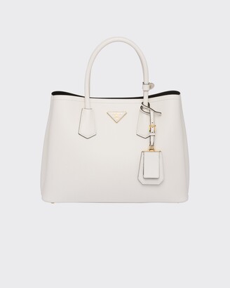 The Prada Double bag in Saffiano Cuir leather comes with a double handle  and detachable shoulder strap. A flap pocket …