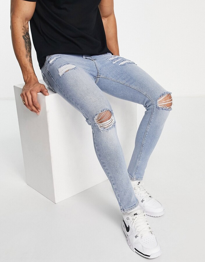 ASOS DESIGN spray on 'vintage look' jeans with power stretch in light wash  blue with heavy rips - ShopStyle