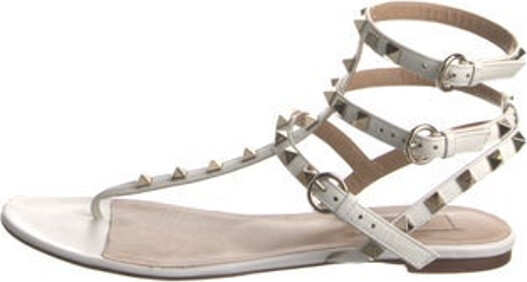 Valentino Leather Gladiator Sandals Neutrals Rockstud Accents Studded Accents Wrap-Around Straps & Buckle Closure at Ankles Includes Box & Dust Bag Unfortunately, due to restrictions, this item may not be eligible for shipping in all areas.