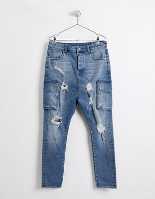 ASOS DESIGN drop crotch jeans in mid wash blue with cargo pockets and rips