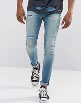 Thumbnail for your product : ASOS DESIGN Super Skinny Jeans In Vintage Mid Wash Blue With Rip And Repair Detail