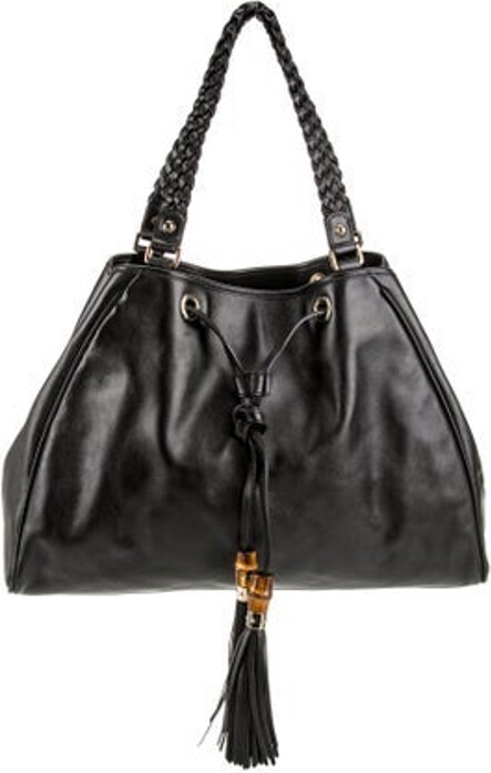 Gucci Shoulder Bag Black Leather Bamboo Accent Gold-Tone Hardware Dual Shoulder Straps Braided & Tassel Accents Canvas Lining & Single Interior Pocket Open Top Protective Feet at Base Unfortunately, due to restrictions, this item may not be eligible for shipping in all areas.