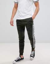 Thumbnail for your product : Hollister print logo camo print skinny joggers in olive green