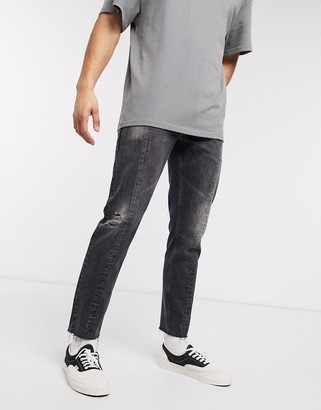 ASOS DESIGN slim jeans in washed black with raw hem and seam detail