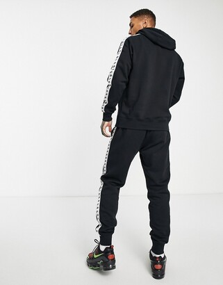 Nike Repeat logo taped fleece tracksuit set in black - ShopStyle Trousers