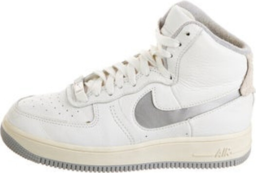 Nike Leather High Top Athletic Sneakers Metallic & White Leather Trim Round-Toes with Lasercut Accents Lace-Up Closure at Uppers Unfortunately, due to restrictions, this item may not be eligible for shipping in all areas.