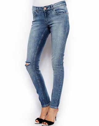 ASOS Whitby Low Rise Skinny Jeans in Randolph Mid Wash Blue With Ripped Knee